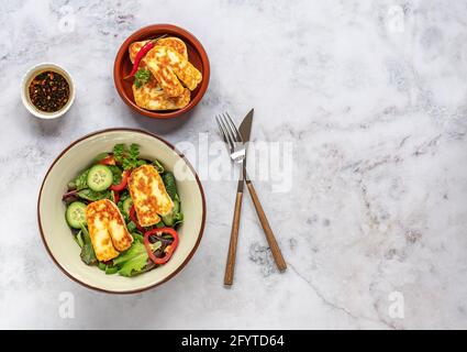 Insalata di formaggio Halloumi fritta con cetriolo, paprika, cipolla verde e foglie. Foto Stock