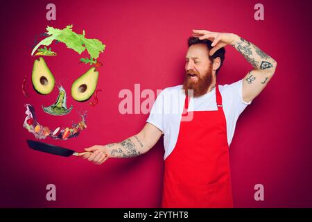 Uomo chef con padella in mano agisce come un stregone Foto Stock