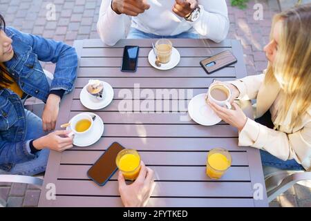 Vista dall'alto della gente che beve qualche bevanda seduto al tavolo sulla terrazza di un bar. Foto Stock