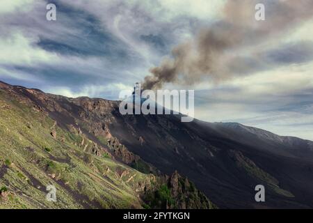 Eruzione di fumo dal cratere Sud-Est del Vulcano Etna in Sicilia e ripido pendio della Valle di Bove Foto Stock