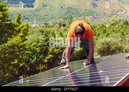 Gli operai assemblano il sistema di energia con il pannello solare per l'elettricità Foto Stock