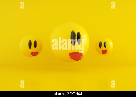 tre emoticon che mostrano la lingua su sfondo giallo, rendering 3d, immagine panoramica Foto Stock