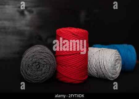 Corde e corde di cotone rosso, bianco, blu, grigio adatte per l'uso in lavori di ago e artigianato macramé. Foto Stock