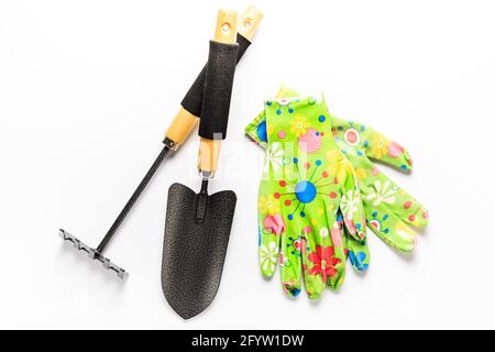 Attrezzi da giardino con guanti da giardino su sfondo bianco. Concetto di giardinaggio. Foto Stock
