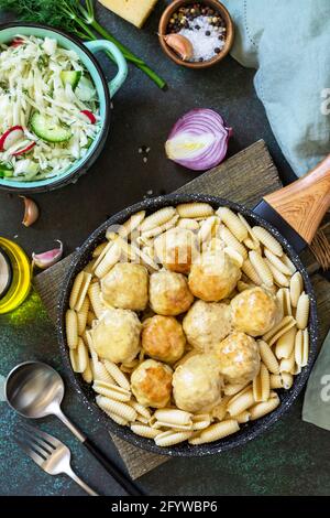 Pasta italiana. Spaghetti con polpette in salsa di formaggio su fondo di pietra scura o calcestruzzo. Foto Stock