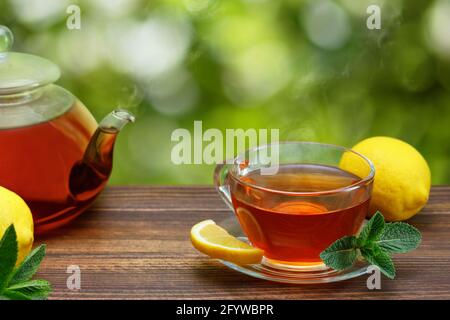 tè caldo con limone e menta in una tazza di vetro Foto Stock