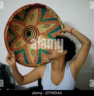 Addis Abeba - Ottobre 2011: Ragazza etiope che tiene un Mesob: Un cesto di vimini rotondo intrecciato usato per servire injera (piatto locale tradizionale) Foto Stock