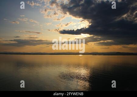 Bellissima alba sul Mare del Nord e fiordi in barca verso Bergen, Norvegia. Riflessi nell'oceano e luce arancione della mattina presto Foto Stock