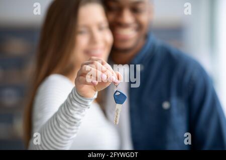 Concetto di bene immobile. Primo piano di una coppia sposata Interrazziale che tiene le chiavi di casa Foto Stock