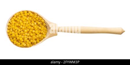 vista dall'alto del cucchiaio di legno con pasta al pittim non cotta (Couscous israeliano) isolato su sfondo bianco Foto Stock