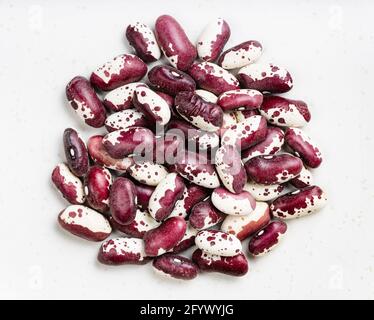 cumulo di fagioli rossi macchiati rene primo piano su grigio piastra in ceramica Foto Stock