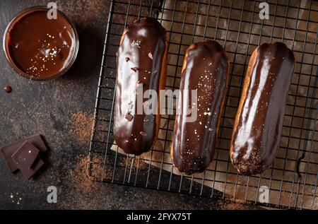 Profiteroles smaltati al cioccolato su sfondo scuro. Dessert fatto a mano. Immagine orizzontale. Vista dall'alto Foto Stock