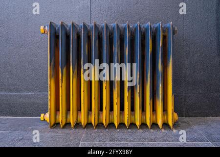 radiatore retrò in ferro grunge verniciato con blu e giallo Foto Stock