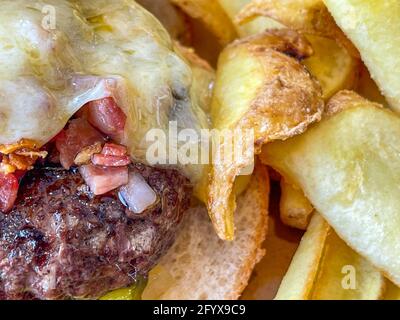 Primo piano di succulenti hamburger appena grigliati con patatine fritte Foto Stock