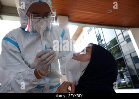 Giacarta, Indonesia. 29 maggio 2021. Gli operatori sanitari che indossano dispositivi di protezione individuale (PPE) prelevano campioni di tampone dai residenti per testare il virus della corona COVID-19 nell'area di Cinere, nel sud di Giacarta, Indonesia. Il virus corona (Covid-19) sta ancora colpendo alcune parti del mondo. (Foto di Kuncoro Widyo Rumpoko/Pacific Press) Credit: Pacific Press Media Production Corp./Alamy Live News Foto Stock