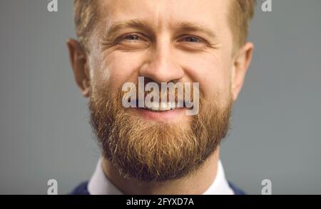 Primo piano ritratto di felice bell'uomo con barba folta allo zenzero sorridendo alla macchina fotografica Foto Stock