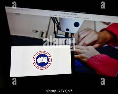 Persona titolare smartphone con logo della societa di abbigliamento invernale Canada Goose Holdings Inc. Sullo schermo di fronte al sito web. Mettere a fuoco il display del telefono Foto stock Alamy