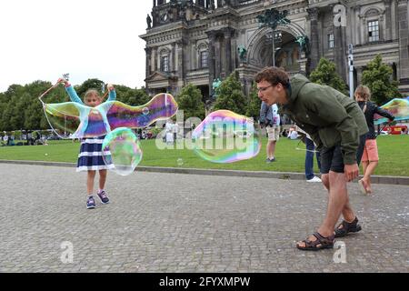 Un bambino fa grandi bolle di sapone sull'isola del museo Foto Stock