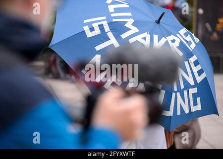 Amburgo, Germania. 27 maggio 2021. Un reporter filma il rally Extinction Rebellion con la sua macchina fotografica. Diversi gruppi locali di ribellione per l'estinzione hanno chiesto una migliore copertura della crisi climatica in caso di azioni decentrate di fronte alle case dei media sotto lo slogan "crisi climatica sulle prime pagine". Credit: Jonas Walzberg/dpa/Alamy Live News Foto Stock