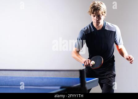 Teenager che gioca a ping pong ping pong. Attrezzatura, in movimento. Foto Stock