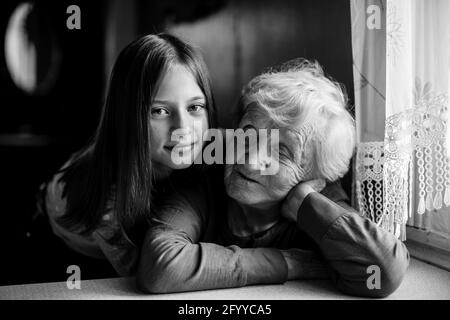 Granny. Bambina carina abbracca la sua vecchia nonna. Foto in bianco e nero. Foto Stock