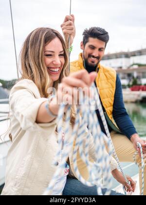 Content Donna con fidanzato etnico che trascorre il tempo in yacht nel porto cittadino di giorno Foto Stock