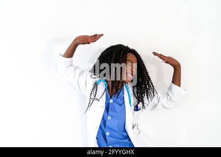 Donna afro-americana in uniforme medica danza in studio medico durante la pausa Foto Stock
