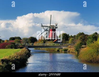 Vista da UN ponte sul canale ai famosi Twin Mills Di Greetsiel Frisia Est in UN giorno di autunno soleggiato con Un cielo blu chiaro e alcune nuvole grandi Foto Stock