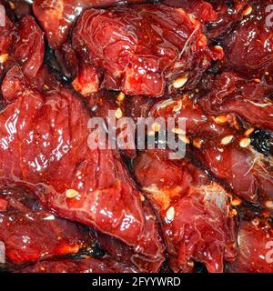 Fette di manzo marinate, luminose e succose, con spezie, olio e semi di sesamo Foto Stock