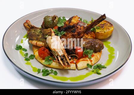 piatti di pesce alla griglia in stile arabo e carne mescolano con gamberi, agnello, manzo, pollo su pane piatto, speciale ramadan Foto Stock