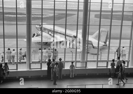 Visitatori che guardano gli aerei attraverso la finestra della sala d'attesa principale presso l'aeroporto municipale di Washington, DC, luglio 1941 Foto Stock