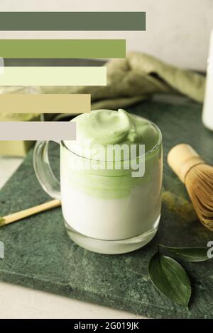 Tazza di gustoso latte di dalgona matcha sul tavolo. Diversi motivi di colore Foto Stock