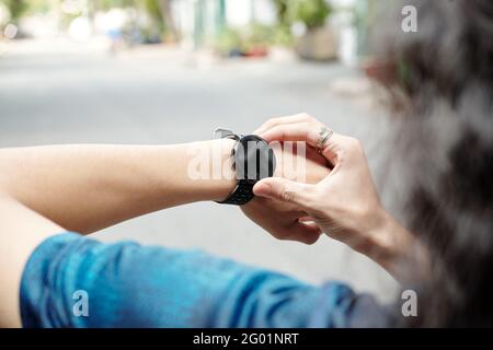 Primo piano di un uomo irriconoscibile in piedi su strada e attività di controllo tracker dopo l'esecuzione Foto Stock