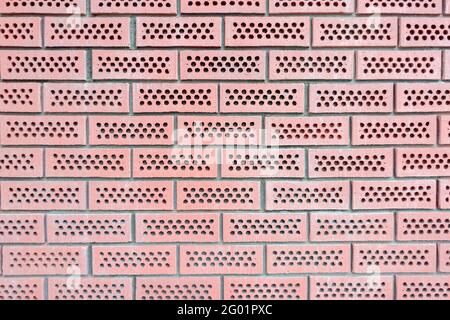 Sfondo rosso forato muro mattoni Foto Stock
