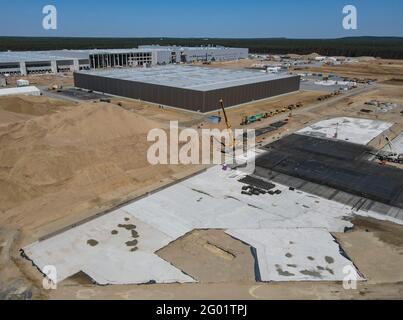 30 maggio 2021, Brandeburgo, Grünheide: Sul cantiere del Gigafactory di Tesla ad est di Berlino, è in costruzione la fondazione di un altro edificio (vista aerea con un drone). Secondo Tesla, la produzione e la consegna dei primi veicoli in questa sede non inizieranno fino alla fine del 2021. Foto: Patrick Pleul/dpa-Zentralbild/dpa Foto Stock