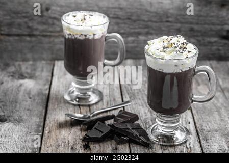 Tazza di cioccolata calda con panna montata, bevanda in un bicchiere, concetto di dessert invernale Foto Stock