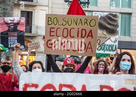 Barcellona, Catalogna, Spagna. 29 maggio 2021. Il manifestante è visto con un banner che recita, Bolsonaro genocidal.on il giorno segnato da manifestazioni nelle principali città del Brasile contro il presidente brasiliano, Jair Bolsonaro. I brasiliani che si trovano a Barcellona hanno tenuto una manifestazione sulle Ramblas di Barcellona per unirsi alle proteste del loro paese natale Credit: Thiago Prudencio/DAX/ZUMA Wire/Alamy Live News Foto Stock