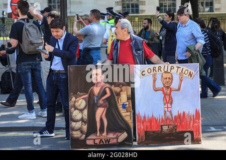 L'artista Kaya Mar con due dei suoi quadri politici satirici commentando l'arrivo del presidente turco Tayyip Erdogan a Londra, Regno Unito Foto Stock