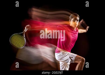 Un uomo, un giocatore di tennis maschile, isolato in misto luce al neon su sfondo scuro. Concetto di sport, gara di squadra. Foto Stock