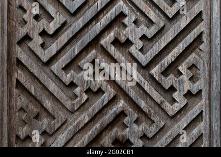 Sfondo di scultura in legno balinese. Motivi angolari grafici sulle porte. Foto Stock