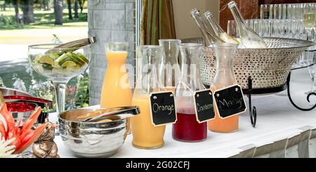 Varie bevande a base di succo in una bottiglia di vetro su un hal alla reception Foto Stock