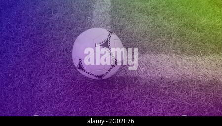 Composizione del calcio su linea bianca sul campo d'erba con spazio di copia e tinta viola Foto Stock