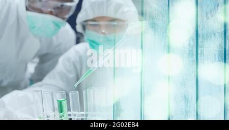 Composizione di scienziati in tute ppe con provette funzionanti in laboratorio e spazio di copia Foto Stock