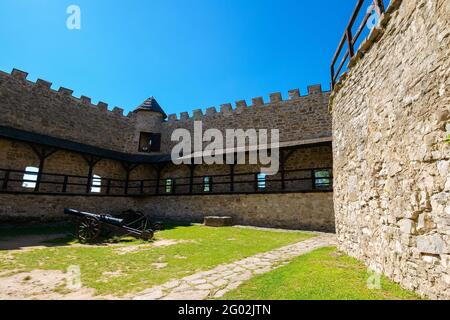 Stara Lubovna, Slovacchia - 28 AGO 2016: Antico cannone nel cortile interno del castello. Grandi pareti in pietra di un tregua. Popolare destinazione di viaggio Foto Stock