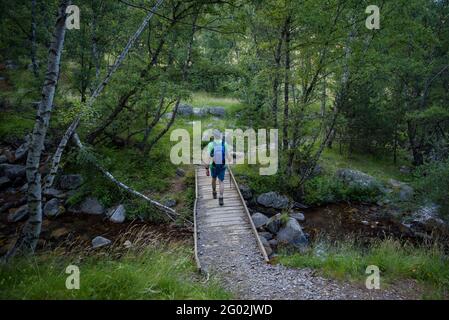 Escursionista che attraversa il fiume Peguera, nella valle Peguera (Pallars Sobirà, Catalogna, Spagna, Pirenei) ESP: Senderista cruzando el Río Peguera Foto Stock