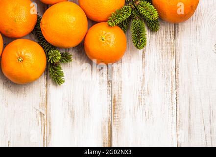 Arance mature su tavola di legno e decorazione con albero di natale filiale Foto Stock