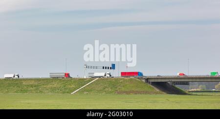 Fila di camion che trasportano il carico sull'autostrada olandese A1 a Deventer, Gelderland Foto Stock