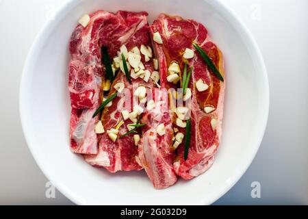 Costolette di agnello con aglio, olio d'oliva ed erbe di rosmarino Foto Stock