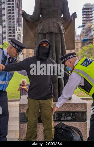 LONDRA, Regno Unito – due funzionari della polizia metropolitana effettuano una ricerca di corpo e arrestano un dimostratore della ribellione estinzione durante una protesta. Foto Stock