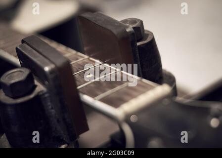 Chitarra con le corde rimosse in riparazione presso un centro di assistenza, primo piano. Foto Stock